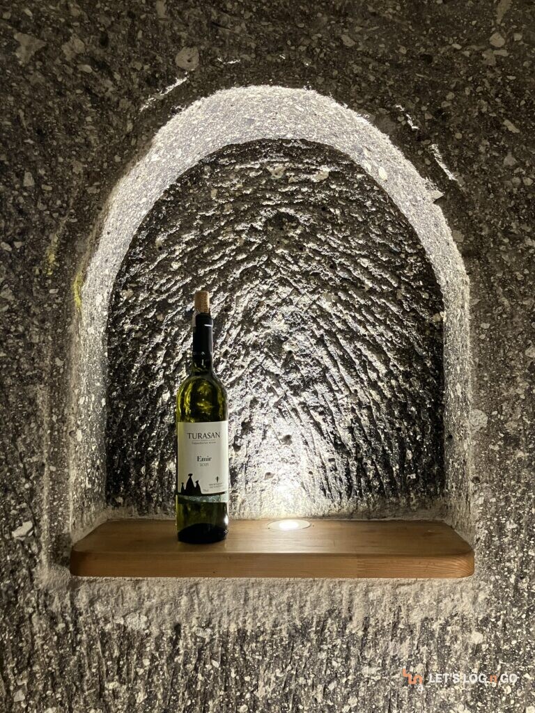 A bottle of TURASAN Emir white wine in a carved stone niche in a Cappadocia cave hotel