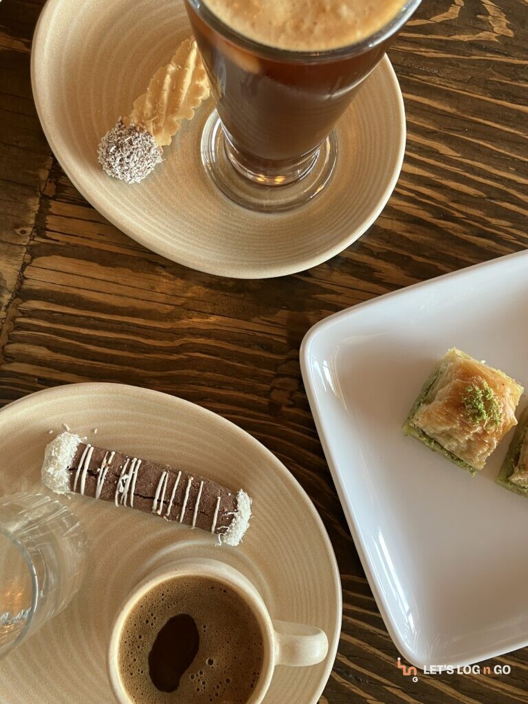Pistachio baklava with Turkish coffee and hot chocolate on a wooden table in Cappadocia